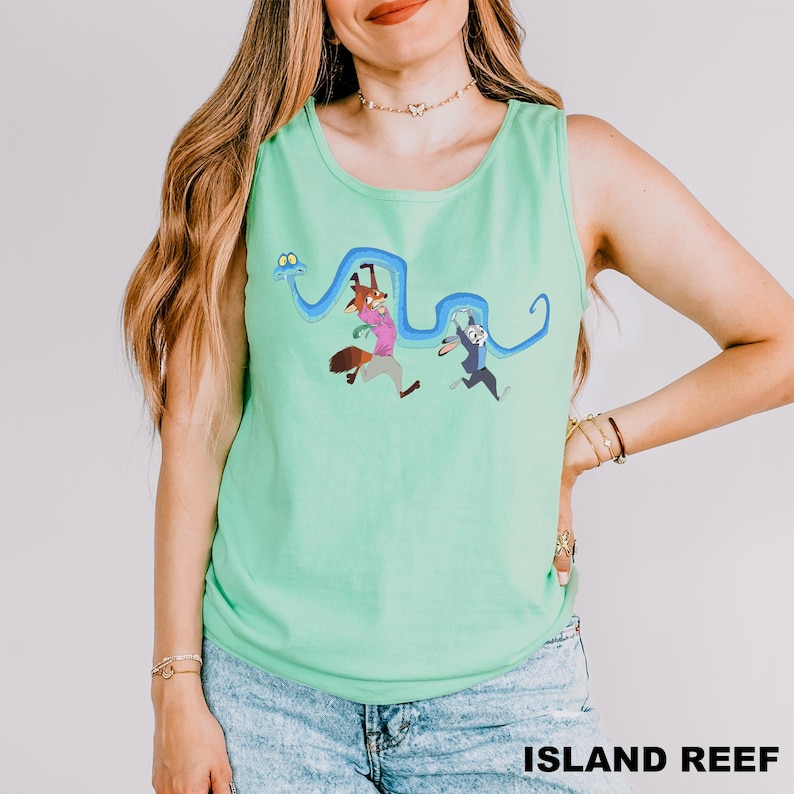 A woman wearing a green tank top with a cartoon character design and a necklace.