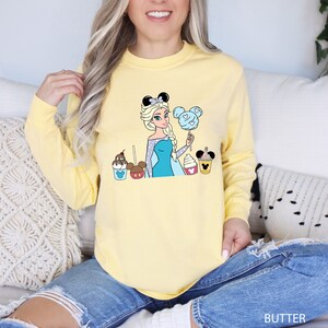 a woman sitting on a couch wearing a yellow shirt