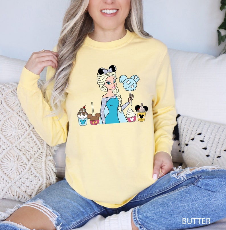 a woman sitting on a couch wearing a yellow shirt