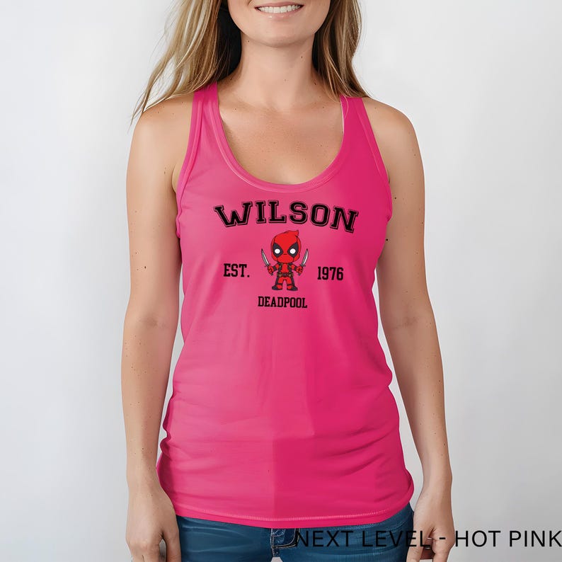 A woman wearing a pink tank top with a graphic of a character from the Marvel Cinematic Universe.