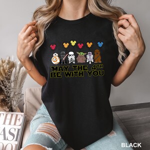 a woman wearing a star wars t - shirt that says may the 4th be with