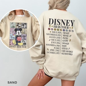 a woman wearing a mickey mouse sweatshirt and shorts