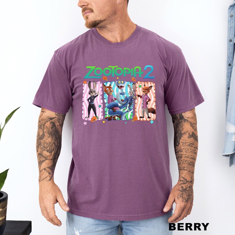 A man wearing a purple t-shirt with a graphic of characters from the animated film "Zootopia 2".