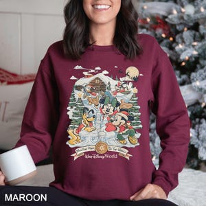 a woman sitting on a bed with a christmas tree in the background