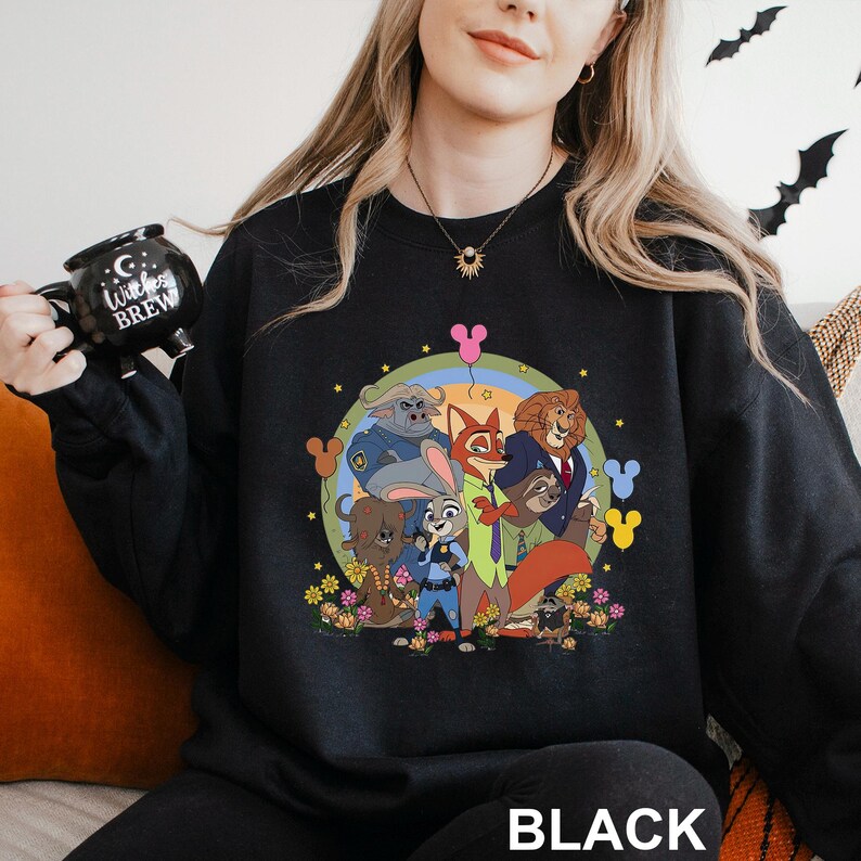 A woman wearing a black sweatshirt with a colorful graphic of cartoon characters from the Disney movie "Jumanji" on it.