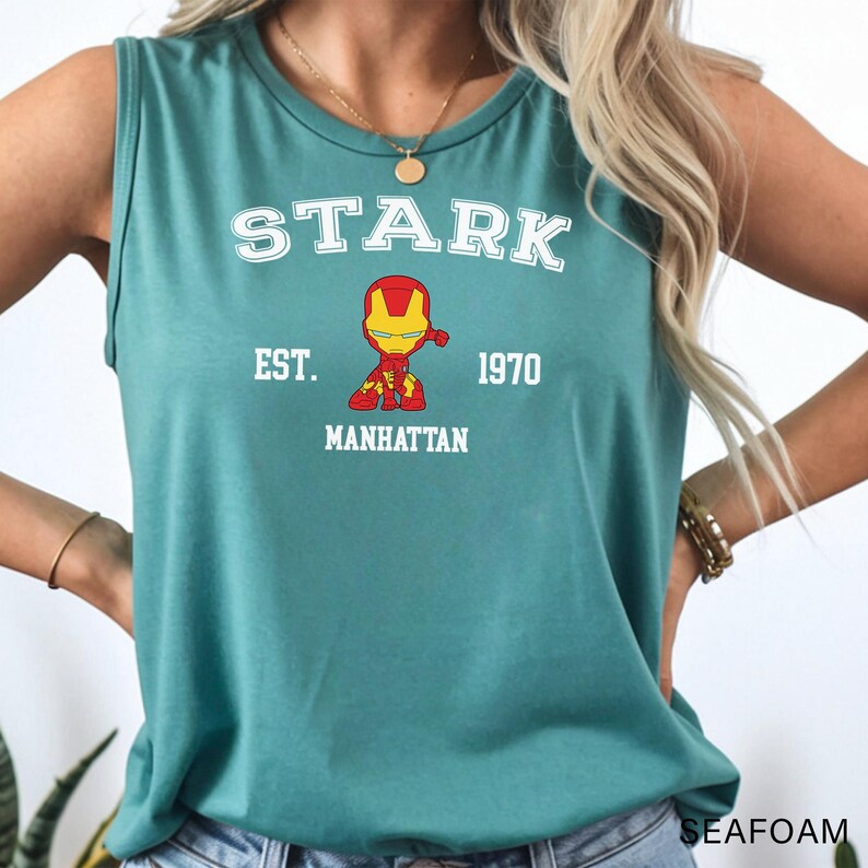A woman wearing a green tank top with a graphic of a character from the Marvel Cinematic Universe.