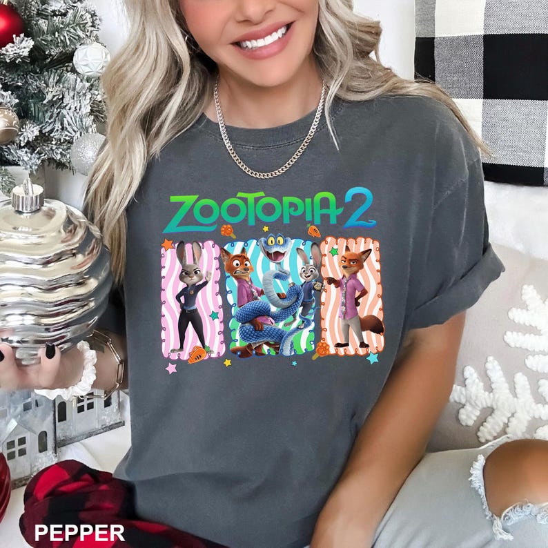 A woman wearing a gray t-shirt with a graphic of characters from the animated film "Zootopia 2" and a necklace.