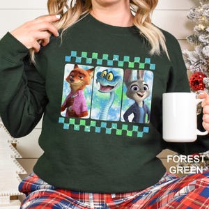 A woman wearing a green sweatshirt with a graphic design featuring cartoon animal characters.