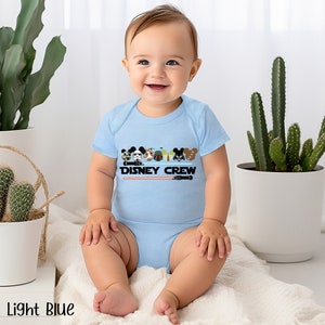 a baby sitting on a blanket next to a potted cactus
