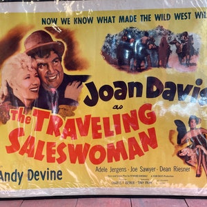 May include: A vintage movie poster for the film "The Traveling Saleswoman" starring Joan Davis and Andy Devine. The poster features a yellow background with red and black text. The poster also includes a scene from the film with Joan Davis and Andy Devine.