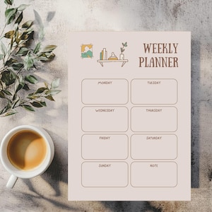 May include: A weekly planner with a light pink background and brown text. The planner has boxes for each day of the week, with the words "WEEKLY PLANNER" at the top. A cup of coffee and greenery are in the image.