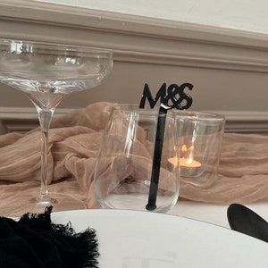Agitador negro con las iniciales “YOU & ME”