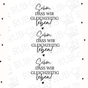 Puede incluir: Fondo blanco con formas de corazón negro dispersas a la izquierda. El lado derecho presenta la frase alemana "Schön, dass wir gleichzeitig leben!" en escritura elegante, repetida tres veces. Cada frase va seguida de un pequeño corazón negro.