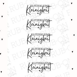 May include: Five black and white stickers with the text "KLITZEKLEINE Kleinigkeit" repeated on each sticker. Each sticker has a small heart symbol below the text.