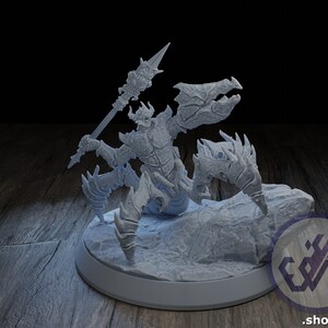 Puede incluir: Una miniatura impresa en 3D gris de una criatura con una cola de escorpión y un torso humanoide que sostiene una lanza. La criatura está de pie sobre una base rocosa.