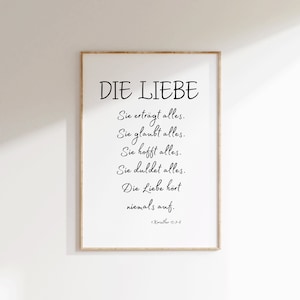 May include: A black and white printable wall art print with a quote about love in German. The quote reads "DIE LIEBE Sie erträgt alles. Sie glaubt alles. Sie hofft alles. Sie duldet alles. Die Liebe hört niemals auf. 1. Korinther 13:7-8"