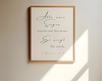 May include: A framed print with a white background and black text in a cursive font. The text reads "Alle eure Sorgen werfet auf Ihn, denn Er sorgt für euch. 1. Petrus 5:7".