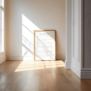 May include: A framed print of Psalm 23 in a light wood frame. The print is on white paper with black text. The frame is hanging on a white wall.