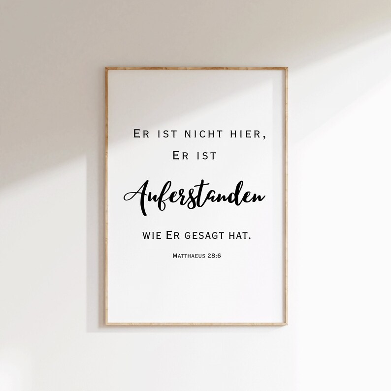 May include: A white framed print with black text that reads "ER IST NICHT HIER, ER IST AUFERSTANDEN WIE ER GESAGT HAT. MATTHAEUS 28:6"