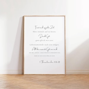 May include: A white framed print with a black and white inspirational quote in German. The quote reads "Freut euch zujeder Zeit! Hört niemals auf zu beten. Dankt Gott. ganz gleich wie eure Lebensumstände auch sein mögen. All das erwartet Gott von euch UND WEIL IHR MIT JESUS CHRISTUS VERBUNDEN SEID, WIRD ES EUCH AUCH MÖGLICH SEIN. 1 Thessalonicker 5:16-18"