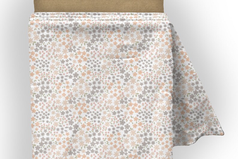 May include: A bolt of white fabric featuring a repeating pattern of small, delicate flowers in shades of soft peach and muted grey. The floral print is densely arranged across the surface, with tiny green leaves interspersed among the blossoms.
