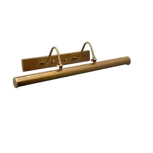 May include: A brass picture light fixture with a rectangular backplate and a cylindrical light bar. Two curved arms extend from the backplate to hold the light bar. The fixture is designed to illuminate artwork.