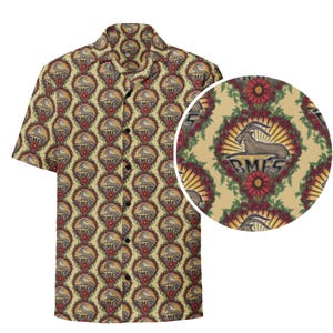 May include: Short-sleeved button-down shirt with an all-over pattern. The design features a repeating motif of a goat within a floral wreath, with the letters "BMFS" below. The shirt has a beige background with red, brown, and gold accents.