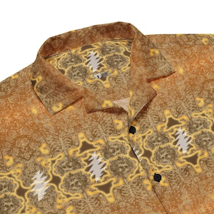 May include: A yellow and brown patterned button-up shirt with a collar. The pattern features a repeating design of a bear's head with a lightning bolt.