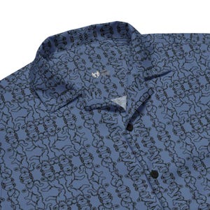 May include: A blue button-down shirt with a repeating pattern of dancing bear figures in black. The shirt has a classic collar and black buttons. The fabric appears to be lightweight, suitable for warm weather.