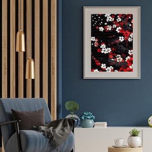 Puede incluir: Una impresión enmarcada de un patrón floral en blanco y negro con flores rojas y blancas. La impresión está colgada en una pared azul en un salón.