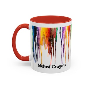 May include: White ceramic coffee mug with a red rim. The mug features a colorful image of melted crayons dripping down the side. The text "Melted Crayons" is printed in black at the bottom of the mug.