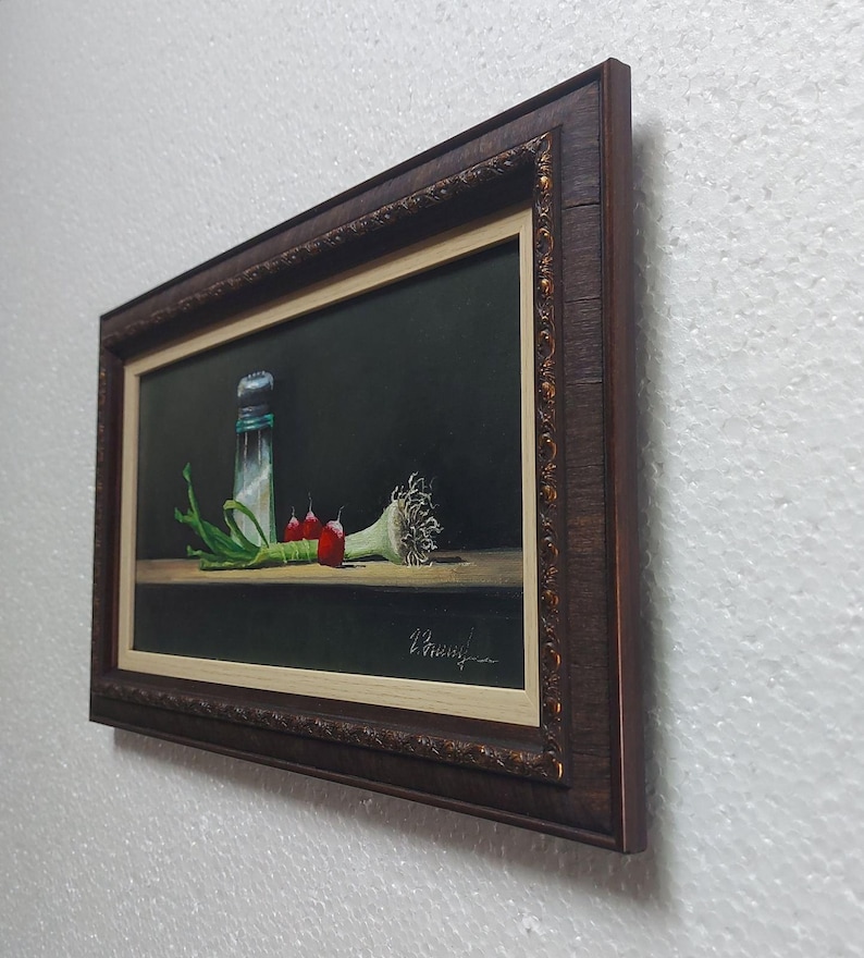 K&ouml;nnte beinhalten: Gerahmtes Stillleben-Gem&auml;lde mit einem Salzstreuer, Fr&uuml;hlingszwiebeln, roten Paprika und einer Knoblauchzehe. Das Kunstwerk ist vor einem dunklen Hintergrund mit einem Holztisch platziert. Der Rahmen ist dunkelbraun mit goldenen Akzenten.