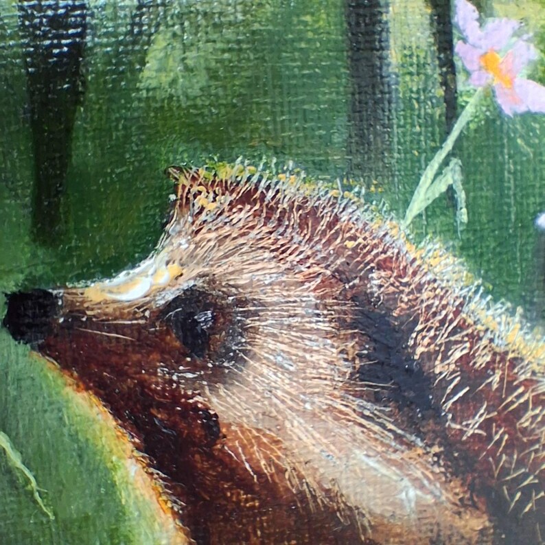 Puede incluir: Una pintura al &oacute;leo sobre lienzo que muestra el perfil lateral de un erizo marr&oacute;n con p&uacute;as texturizadas. El erizo est&aacute; posicionado sobre un fondo de bosque verde con una peque&ntilde;a flor de color p&uacute;rpura claro visible en la esquina superior derecha.