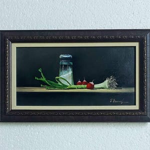 K&ouml;nnte beinhalten: &Ouml;lgem&auml;lde eines Stilllebens mit einem Salzstreuer, Fr&uuml;hlingszwiebeln, Radieschen und einer Knoblauchzehe. Das Kunstwerk ist in einem dunkelbraunen Rahmen gerahmt und vor einem dunklen Hintergrund platziert.
