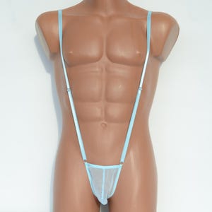 May include: Pale blue lingerie set featuring thin straps and a sheer fabric bottom. The garment is displayed on a mannequin with a muscular torso, against a white backdrop. The straps are attached to the bottom with small metal rings.