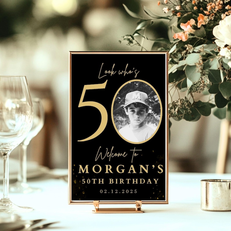 May include: Black and gold table card with the number 50 in gold, the text "Look who's 50", "Welcome to Morgan's 50th Birthday", and the date "02.12.2025". A black and white photo of a young boy wearing a baseball cap is in a gold oval frame.