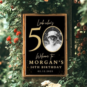 May include: Black and gold birthday sign with the number 50 in gold, the text "Look who's 50", "Welcome to Morgan's 50th Birthday", and the date "02.12.2025". A photo of a young boy wearing a baseball cap is in the center of the sign.