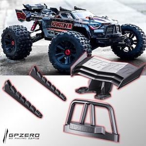 Peut inclure: Un camion télécommandé noir et rouge avec de gros pneus et plusieurs pièces imprimées en 3D noires. Le camion porte le texte "KRATON 8S" sur le côté. Les pièces imprimées en 3D comprennent un aileron arrière, deux supports latéraux et un pare-chocs avant. Le logo "GPZERO 3D RACING PARTS" est en bas.