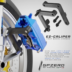 May include: A blue Brembo EZ-CALIPER brake caliper with black brackets and bolts. The text "EZ-CALIPER FAST WHEEL CHANGE" is visible. The product is designed for fast wheel changes and is made in Italy.