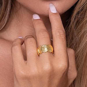 May include: A set of three ceramic nesting bowls in graduating sizes. The bowls are white with a speckled, textured finish and feature a slightly flared rim. The largest bowl measures approximately 8 inches in diameter.