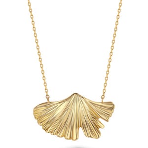 Op de afbeelding: Een goudkleurige ketting met een hanger in de vorm van een ginkgoblad. De hanger heeft een getextureerd, waaiervormig oppervlak met stralende lijnen en hangt aan een fijne, dunne goudkleurige ketting die aan beide zijden van het blad vastzit.