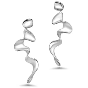 May include: A pair of silver-colored, abstract earrings. Each earring has a flowing, ribbon-like design with a polished, reflective surface. The earrings are displayed against a white background, highlighting their sculptural form.
