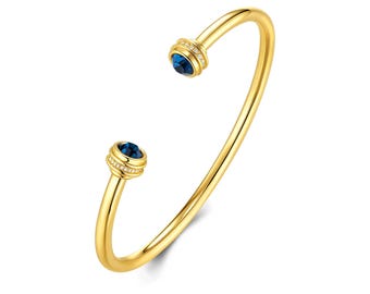 Bracciale rigido a fascia spessa placcato oro 18 carati, ciondolo intrecciato con zaffiro blu e zirconi cubici, bracciale aperto di grande effetto.