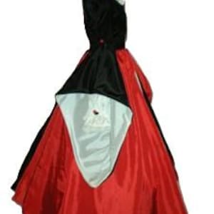May include: A floor-length gown featuring a black bodice and a vibrant red skirt. The garment includes a black overskirt panel with a white lining that drapes over the front, accented by a small red detail at the waist and a white ruffled collar.