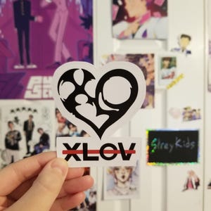 May include: A black and white sticker with a stylized heart design and the word "XLOV" with a red line through it.