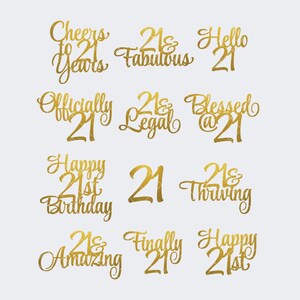 May include: Gold-colored text designs for a 21st birthday celebration. Phrases include "Cheers to 21 Years," "21 & Fabulous," "Hello 21," "Officially 21," and "Happy 21st Birthday."