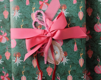 Papel de regalo con motivos de ramas y adornos navideños, ideal para ocasiones especiales.