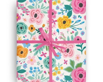 May include: A white gift wrap with a pink ribbon and a floral pattern featuring pink, yellow, orange, blue, and green flowers.