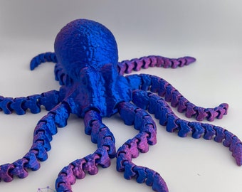 May include: A 3D printed octopus with blue and purple iridescent paint. The octopus has eight tentacles that are segmented and bendable. The octopus is posed with its tentacles spread out.