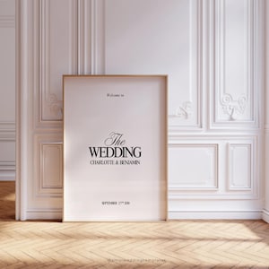May include: A white poster with a gold frame, announcing "The Wedding" of Charlotte & Benjamin on September 27th, 2020.